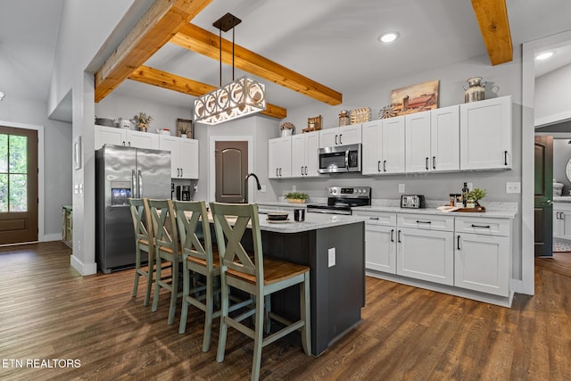 3487 Summit Trails Dr, Sevierville, TN 37862 - kitchen with an island with sink, stainless steel appliances, white cabinetry, beamed ceiling, and dark wood-style floors