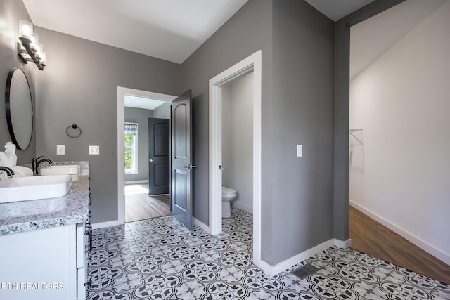 3487 Summit Trails Dr, Sevierville, TN 37862 - full bathroom with double vanity, toilet, baseboards, and a sink