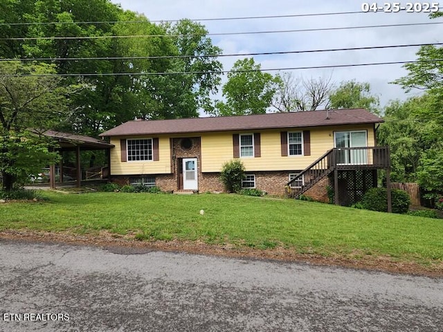 bi-level home featuring brick siding, a front lawn, a wooden deck, and stairway