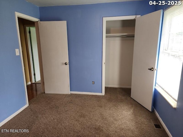 unfurnished bedroom featuring visible vents, carpet, and multiple windows