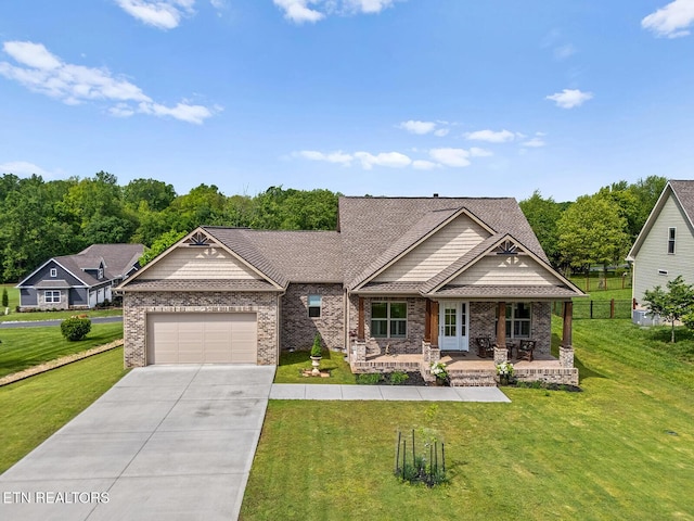 112 Naduli Trl, Vonore, TN 37885 - craftsman-style home featuring covered porch, driveway, a front yard, and a garage