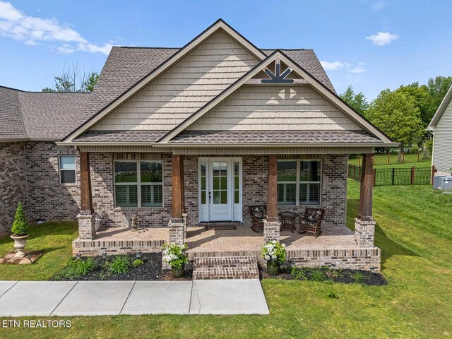 112 Naduli Trl, Vonore, TN 37885 - craftsman inspired home with brick siding, fence, a shingled roof, and a front lawn