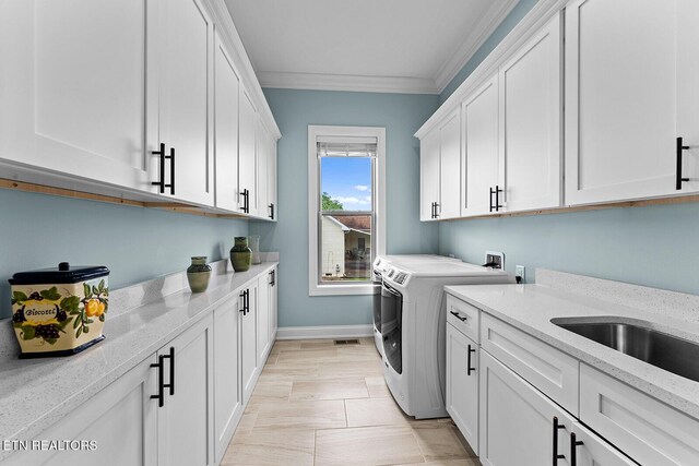112 Naduli Trl, Vonore, TN 37885 - laundry room featuring visible vents, ornamental molding, washing machine and dryer, baseboards, and cabinet space