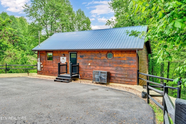 view of outdoor structure featuring driveway and fence