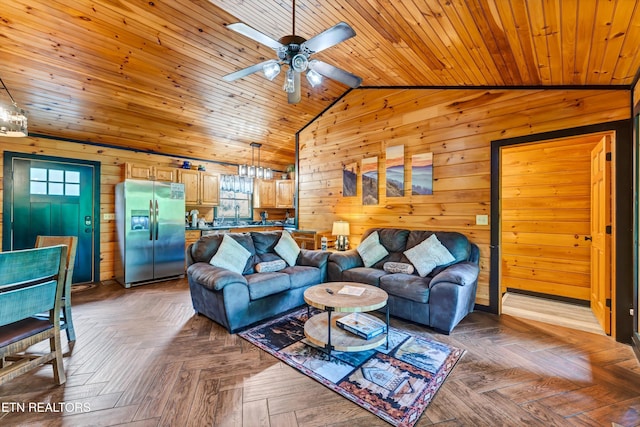 living room featuring a wealth of natural light, vaulted ceiling, and wooden walls
