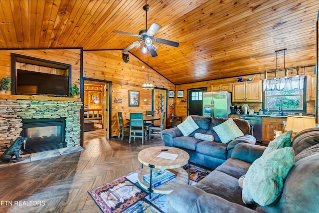 living area featuring lofted ceiling, a ceiling fan, wood ceiling, wood walls, and a fireplace
