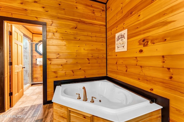 bathroom with wooden walls and a bath