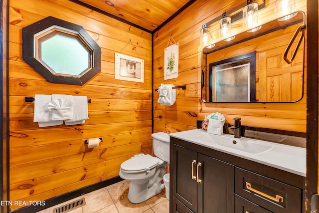 bathroom with toilet, visible vents, wooden walls, tile patterned floors, and vanity