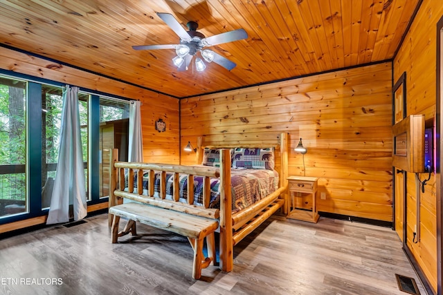 bedroom with wood walls, wood finished floors, visible vents, wood ceiling, and access to outside