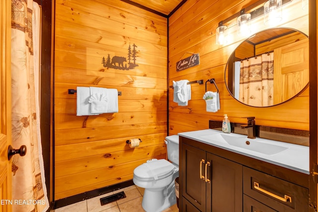 full bath with wood walls, toilet, vanity, visible vents, and tile patterned floors