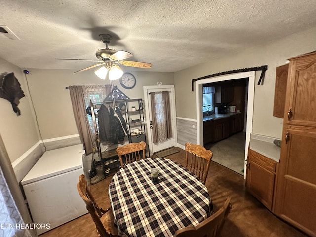 dining space featuring a ceiling fan and a textured ceiling