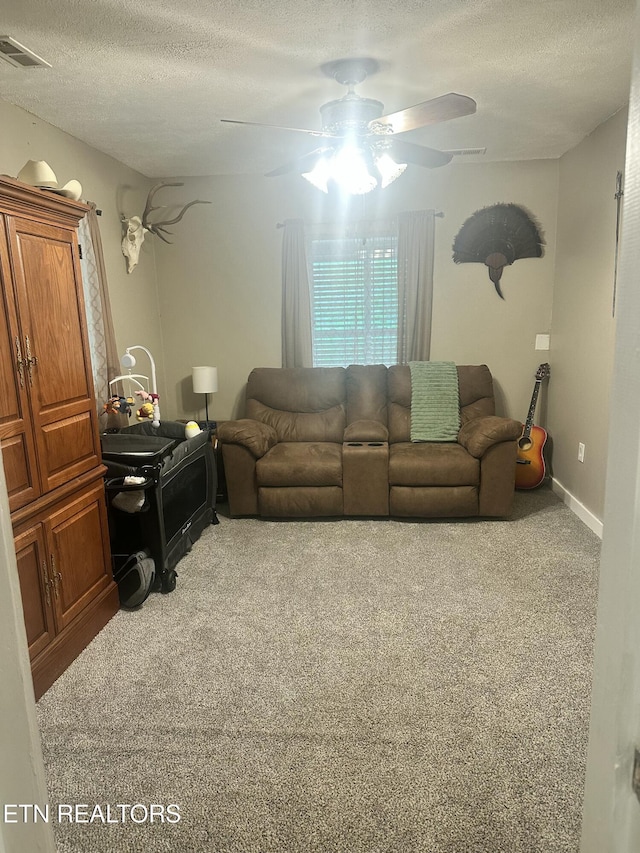 carpeted living room with a textured ceiling and a ceiling fan