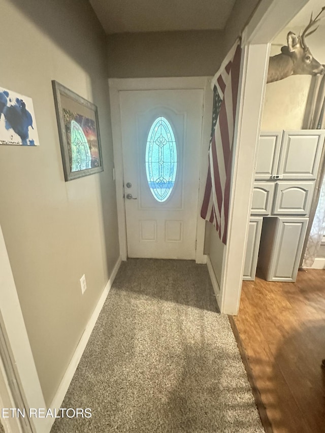 doorway featuring healthy amount of natural light and baseboards