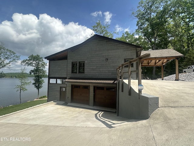 view of front of house featuring an attached garage, a water view, and driveway