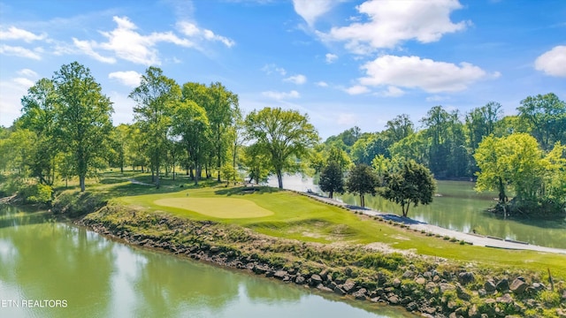 view of property's community featuring a water view, an area to practice putting, and view of golf course