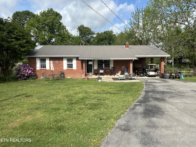 single story home featuring a front yard, brick siding, a porch, driveway, and a carport