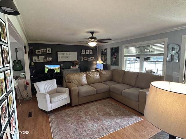 living area featuring crown molding, a textured ceiling, ceiling fan, and wood finished floors