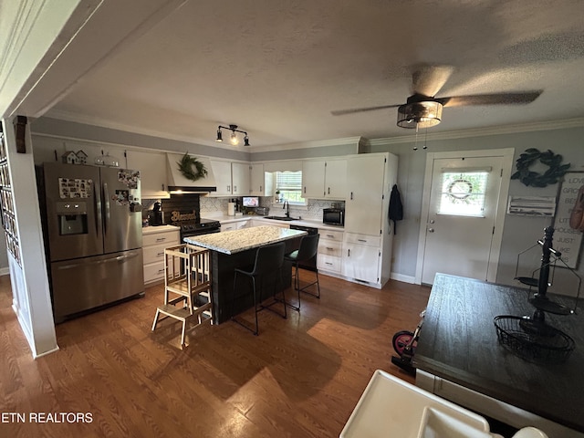 kitchen with a sink, crown molding, black appliances, and white cabinets