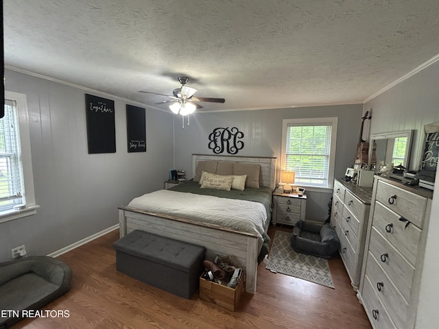 bedroom with crown molding, a ceiling fan, dark wood finished floors, and baseboards