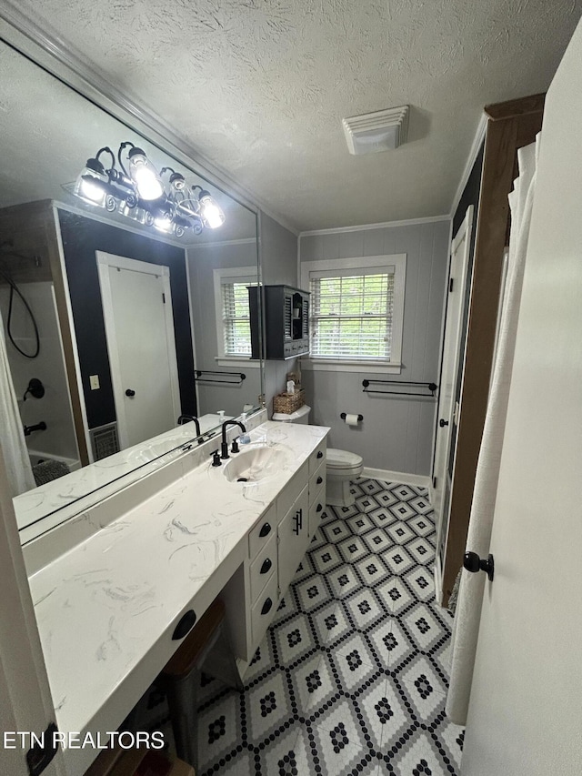 bathroom featuring a textured ceiling, visible vents, vanity, toilet, and ornamental molding