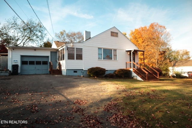 view of front of property with a garage, a front yard, crawl space, a chimney, and driveway