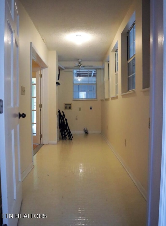 hallway with baseboards and plenty of natural light