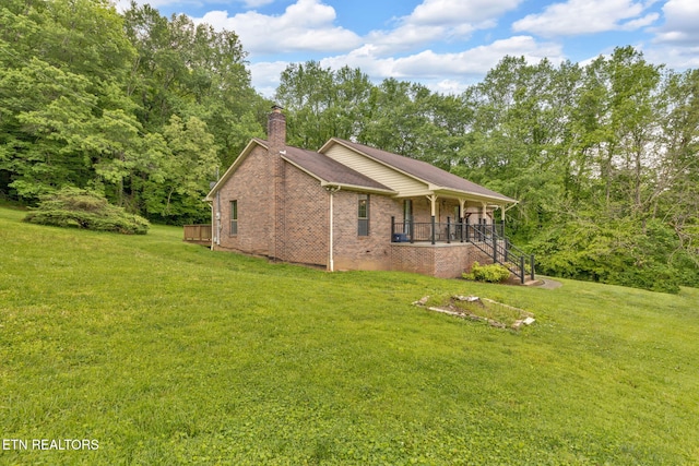 243 Bunch Ln, Clinton, TN 37716 - view of home's exterior featuring covered porch, a yard, a chimney, and brick siding
