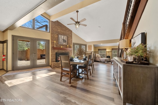 dining room with ceiling fan, french doors, beam ceiling, light wood-style floors, and a wealth of natural light