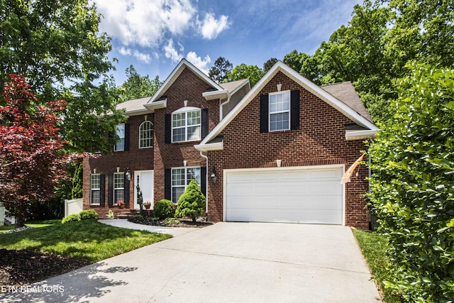 colonial house with a garage, a front lawn, brick siding, and driveway