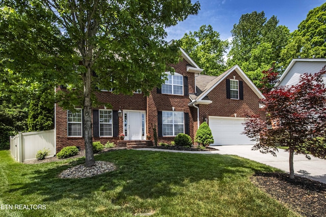 colonial inspired home featuring brick siding, driveway, fence, and a front yard