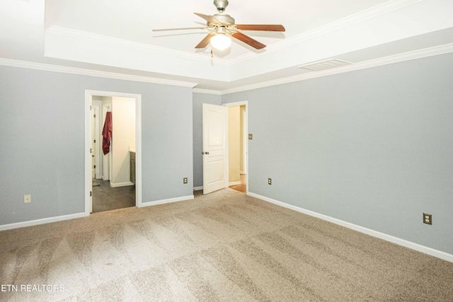 unfurnished bedroom featuring visible vents, connected bathroom, crown molding, a raised ceiling, and carpet floors