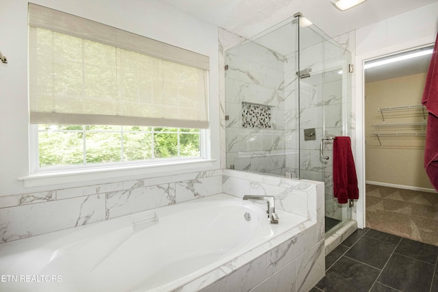 full bathroom featuring a bath, a marble finish shower, and a spacious closet