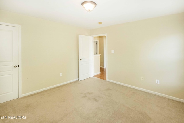 unfurnished bedroom with light colored carpet and baseboards