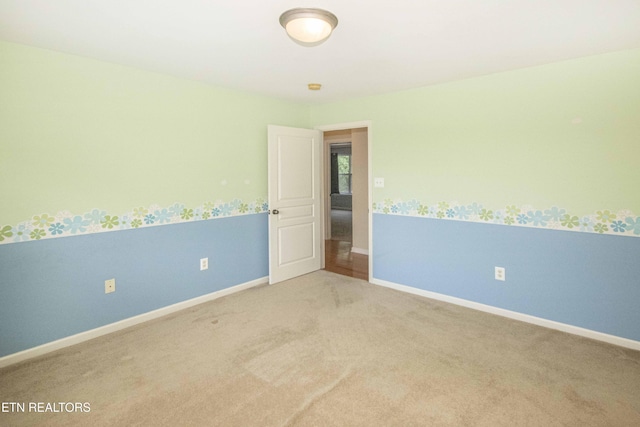 carpeted spare room featuring baseboards