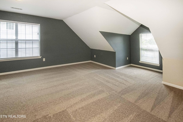 bonus room featuring lofted ceiling, carpet, baseboards, and visible vents