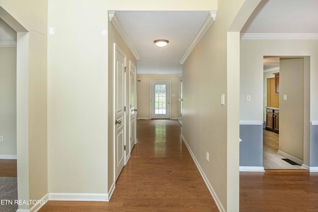 corridor featuring ornamental molding and light wood-style floors