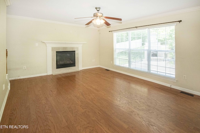 unfurnished living room with ceiling fan, ornamental molding, visible vents, and wood finished floors