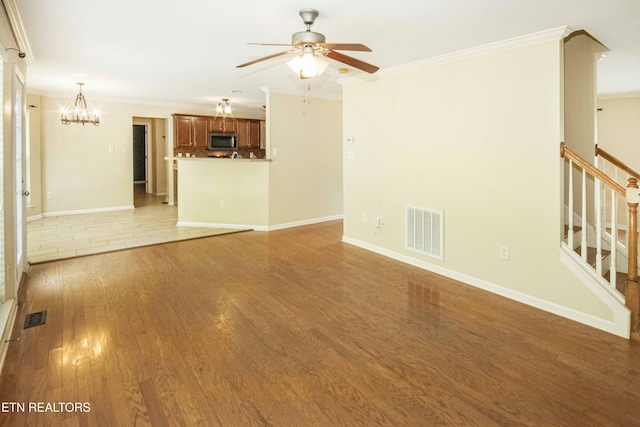 unfurnished living room featuring stairway, ornamental molding, light wood-style flooring, and visible vents