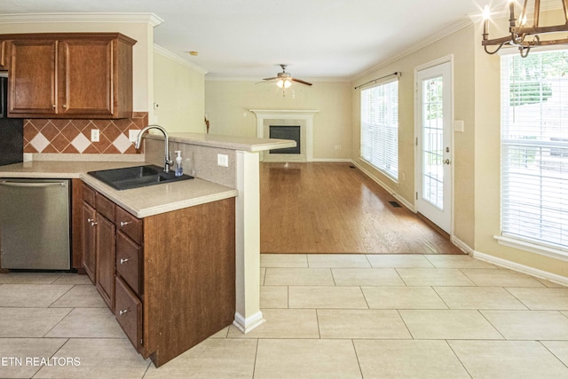 kitchen with a sink, crown molding, ceiling fan with notable chandelier, and dishwasher