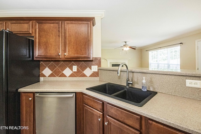 kitchen featuring freestanding refrigerator, dishwasher, ceiling fan, a sink, and tasteful backsplash