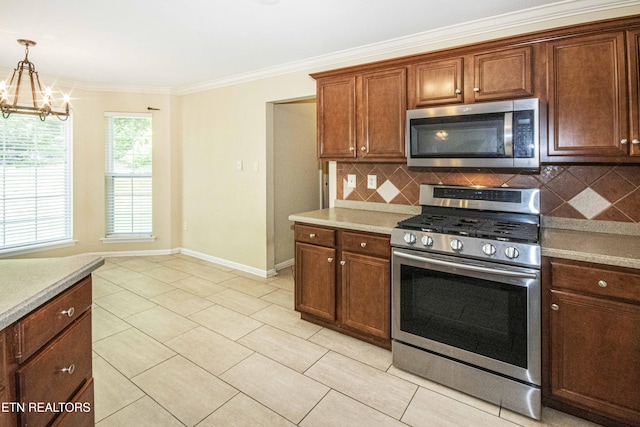 kitchen featuring baseboards, a chandelier, appliances with stainless steel finishes, and decorative backsplash