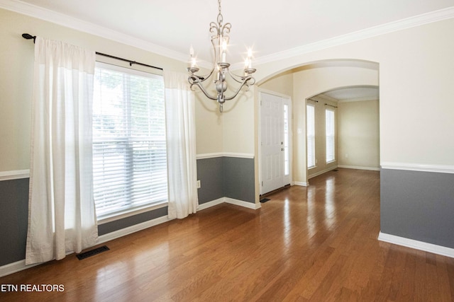 unfurnished dining area featuring an inviting chandelier, visible vents, baseboards, and arched walkways