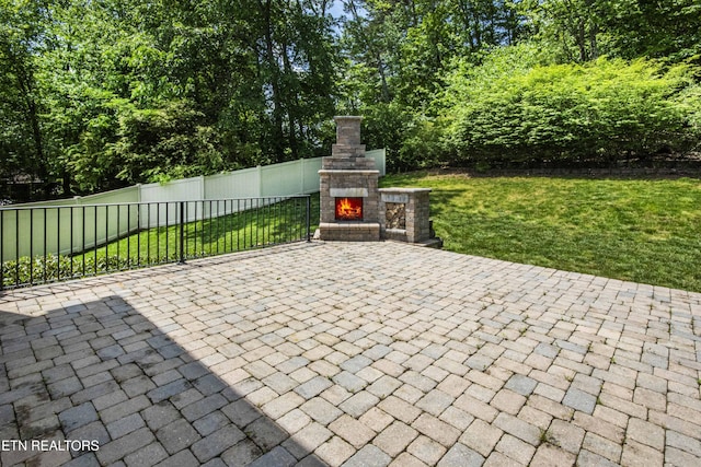 view of patio featuring fence and an outdoor stone fireplace