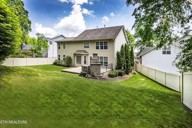 back of house featuring a yard, a patio, and a fenced backyard