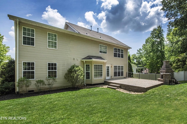 rear view of house with a yard, a patio area, and a fireplace