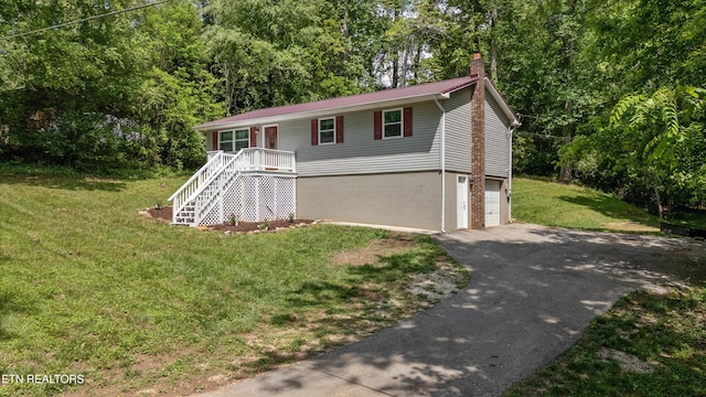 136 White Oak Dr, Harriman, TN 37748 - view of front of home featuring a chimney, a front yard, a garage, stairway, and aphalt driveway