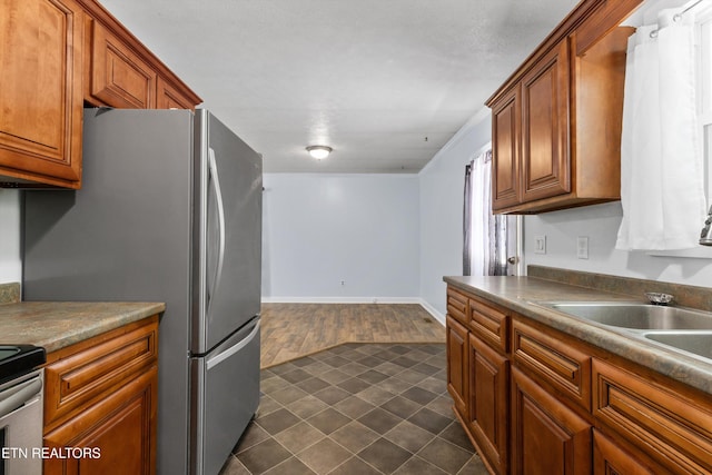 136 White Oak Dr, Harriman, TN 37748 - kitchen with brown cabinetry, freestanding refrigerator, and dark tile patterned floors