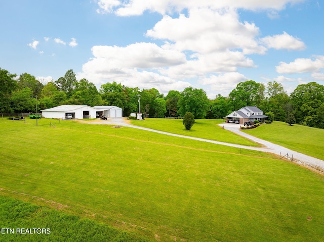 291 County Road 275, Niota, TN 37826 - view of grassy yard featuring driveway, an outdoor structure, a garage, an outbuilding, and view of scattered trees