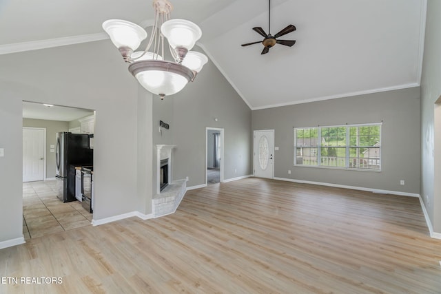 701 Misty Ridge Dr, Lenoir City, TN 37772 - unfurnished living room with ceiling fan, high vaulted ceiling, a fireplace, light wood-style flooring, and baseboards