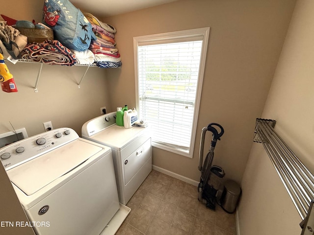laundry area with light tile patterned floors, baseboards, laundry area, and washer and clothes dryer